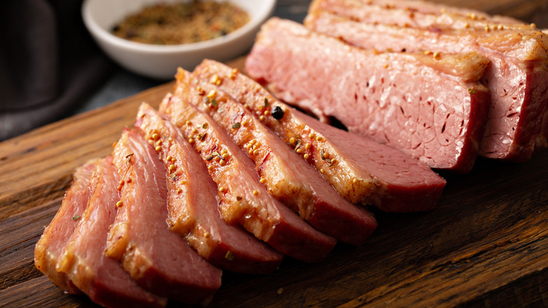 sliced corned beef on wooden board