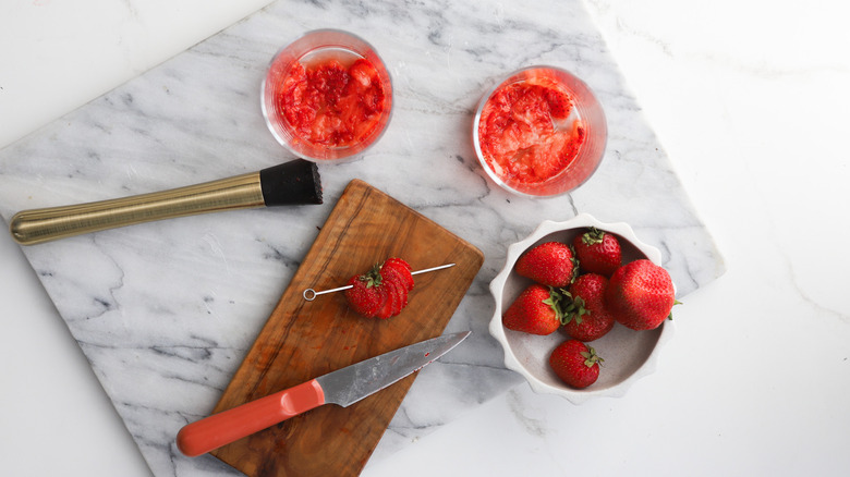 Muddling fresh strawberries in glasses